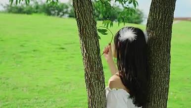 4k实拍女生靠在树枝上人文风光视频的预览图